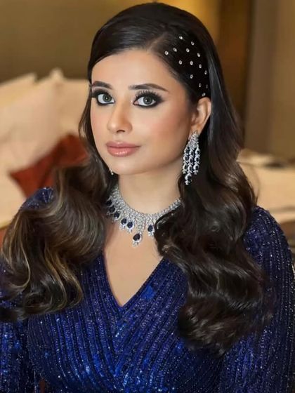 A retro-inspired party look with a modern twist. The hairstyle features a jeweled headband, paired with a classic smokey eye.