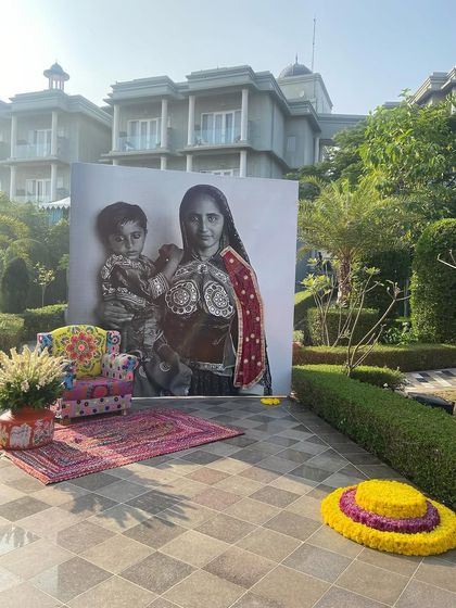 Another creative photo corner, this time with a large, striking portrait of a woman in traditional attire. The setup, complete with a colorful armchair and rug, celebrates the beauty and spirit of the theme.
