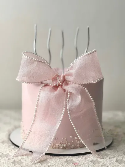 A pretty pink cake featuring our signature ribbon bow. The simplicity of the design, with the large, perfectly crafted bow, makes it a client favorite.