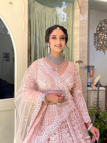 The final look for this engagement ceremony. The soft, romantic updo complements her pastel lehenga and diamond jewelry perfectly.