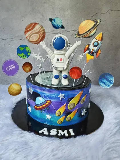 Another journey into the cosmos with this space-themed cake. This design features a vibrant, hand-painted galaxy, a UFO, comets, and a full solar system of planets for an astronomical celebration.