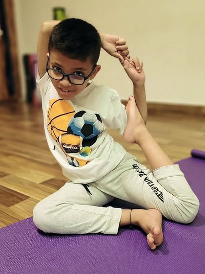 This little yogi is practicing a variation of Eka Pada Rajakapotasana, or mermaid pose. It is a beautiful stretch for the hips and quadriceps, and I am always amazed by the natural flexibility of children.