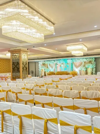 A beautiful hall setup in Vashi with white and gold chair covers and a stunning crystal chandelier. We offer this hall with premium decoration for just 99k.
