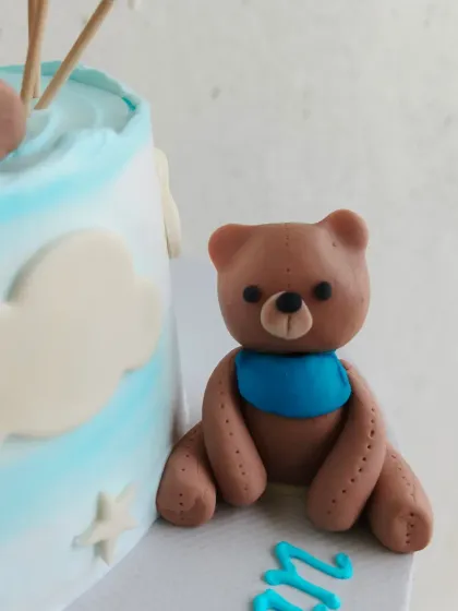 Another cute fondant bear sitting beside the half birthday cake.