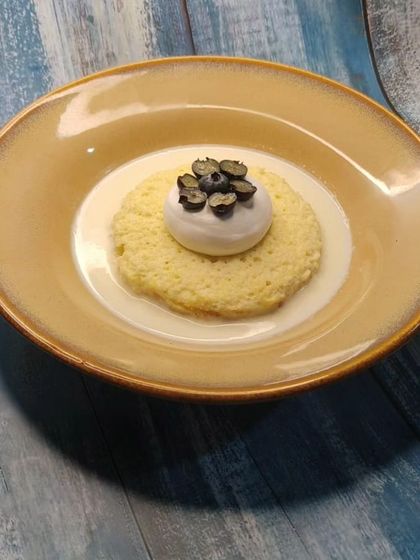 A beautifully plated Tres Leches cake with a blueberry topping.