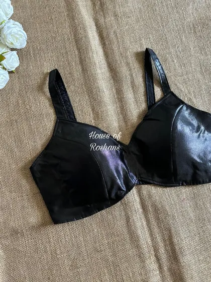 A sleek and modern black faux leather bralette blouse. This is a bold choice for a contemporary saree look or a night out.