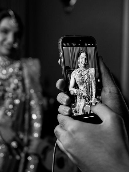 Capturing the final look on my phone. This black and white shot shows a behind-the-scenes moment of me documenting the bride's complete look before she steps out.