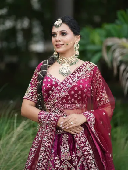 A full-length shot showing the bride's complete look against a lush green background.