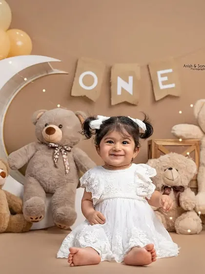 Look at that happy face! Before the smashing began, we captured this sweet portrait of the birthday girl in her beautiful white dress, surrounded by her teddy bear friends.
