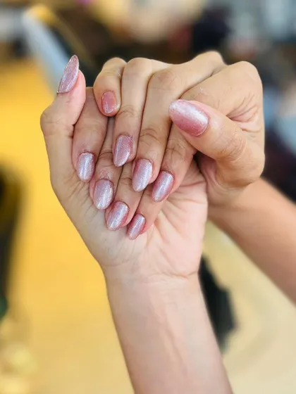 For a softer look, this manicure uses a pearlescent pink polish with a beautiful shimmer. The almond shape keeps the style modern and elegant.