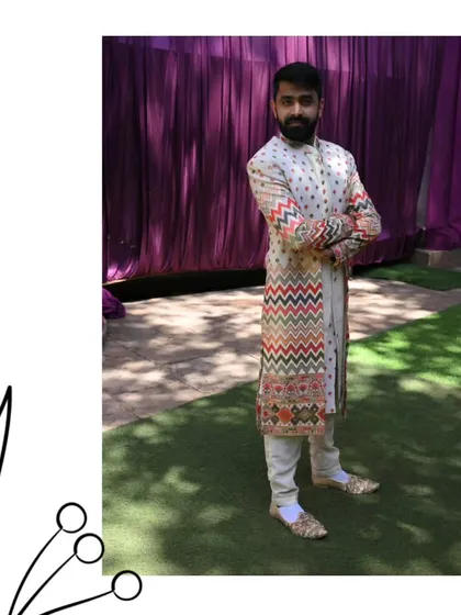 We've got ethnic elegance. This client is wearing a unique off-white sherwani with colorful chevron embroidery, a perfect blend of tradition and modern design.