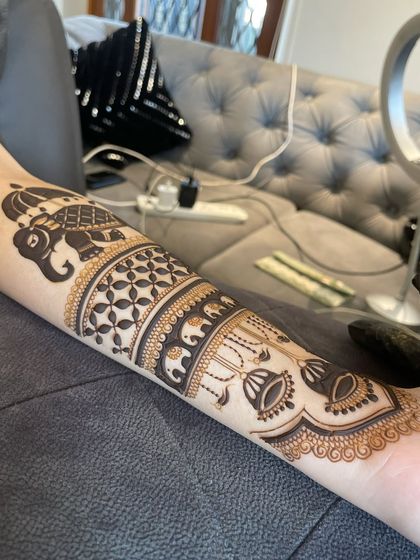 An elegant arm band design featuring a royal elephant, jhumka motifs, and delicate check patterns. This is a great choice for non-bridal festive wear.