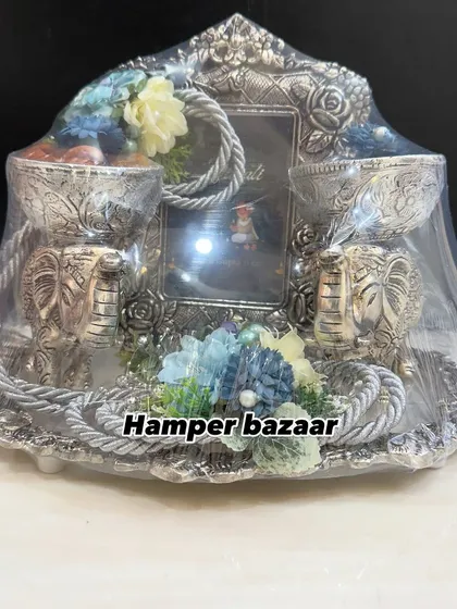 This German silver platter is pure elegance. It features two elephant shaped bowls for dry fruits, a beautiful photo frame, and floral decorations, making it a stunning centerpiece and a memorable Diwali gift.