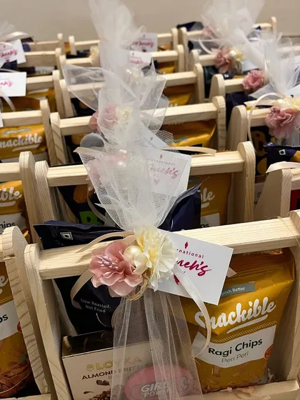 Gorgeous wooden gift baskets curated for the women at Angular Minds on International Women's Day, filled with healthy snacks and treats.