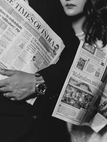 A close up on the newspapers and their hands. This detailed shot in black and white adds to the vintage, journalistic theme of their creative shoot.