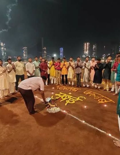 A senior member performing the puja rituals, with all players praying together.
