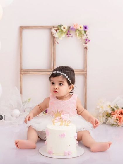 Poised and pretty before the smashing begins. This portrait captures the calm before the fun, with a beautiful cake and balloon arrangement.
