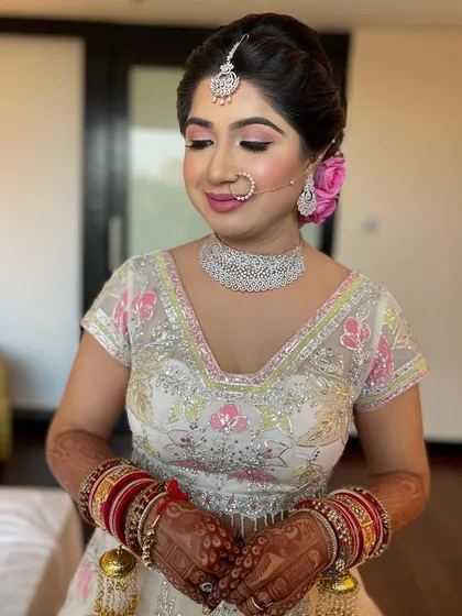 A beautiful bridal bun with fresh pink roses tucked in. This is a classic way to add romance and color to a wedding day hairstyle.