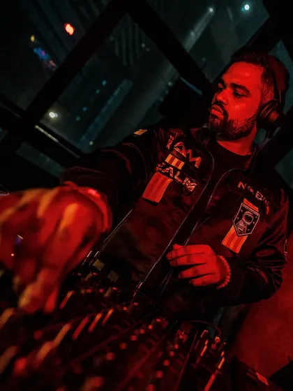 A close-up of me at the decks, bathed in red light. This shot highlights the focus and precision that goes into every mix.