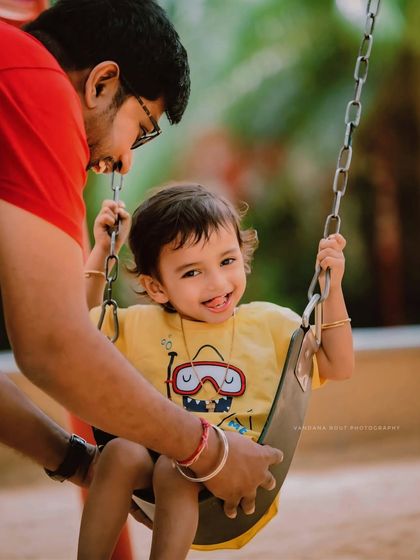 Pure happiness on the swing set. A father gives his son a push, and the resulting smile is a priceless, candid moment captured during their outdoor session.