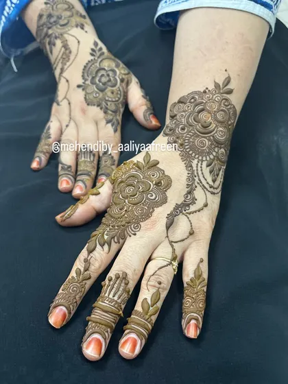 A simple and short design featuring a floral motif on the back of the hand and detailed finger caps.