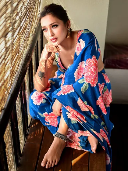 Mimi Chakraborty looking pensive, framed by a window. The natural light beautifully illuminates her profile, creating a classic and timeless portrait.