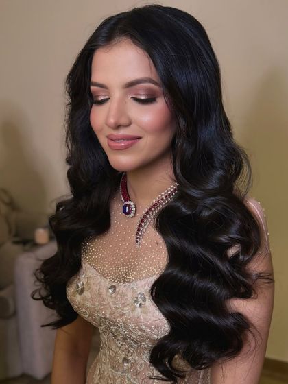 The bride with her eyes closed, showcasing her soft glam makeup and the texture of her voluminous waves.