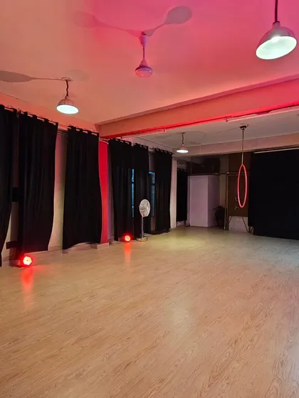 A wide view of the studio, set with a bold red lighting scheme. The open floor plan and blackout curtains give you complete control to build the world you envision for your workshop, rehearsal, or shoot.