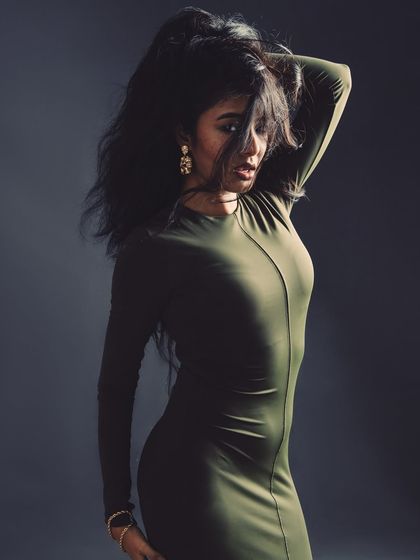 A full-body shot showing the model's pose and the flow of her hair and dress.