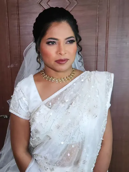 A beautiful Christian wedding look with a white saree. The makeup is soft and elegant, with a focus on the eyes.