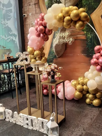 I love bringing vibrant and stylish birthday visions to life. This circular balloon arch with elegant gold, pink, and white balloons, paired with custom marquee letters, creates a stunning focal point for any party at a cafe or at home.