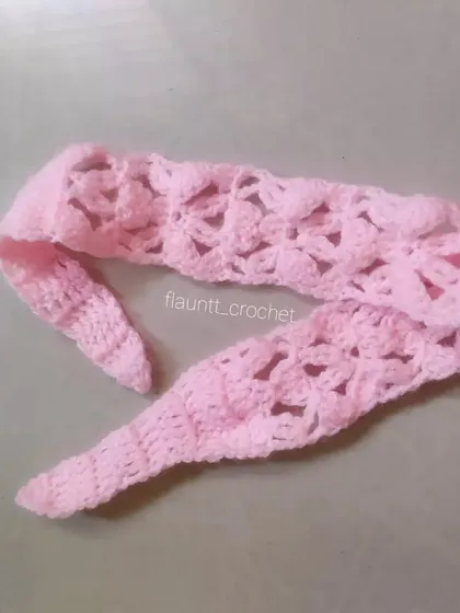 Another view of the pink crochet headband, showing the tapered ends that make it easy to tie.