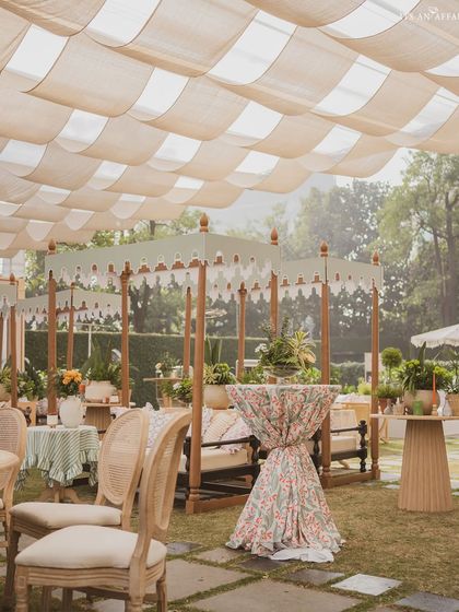 Tented cabanas with floral-print cocktail tables create intimate and stylish spaces for guests to gather.