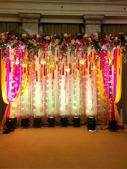 A wider view of the colorful Haldi stage, showing how the vibrant drapes and floral decor create a perfect backdrop for the ceremony.