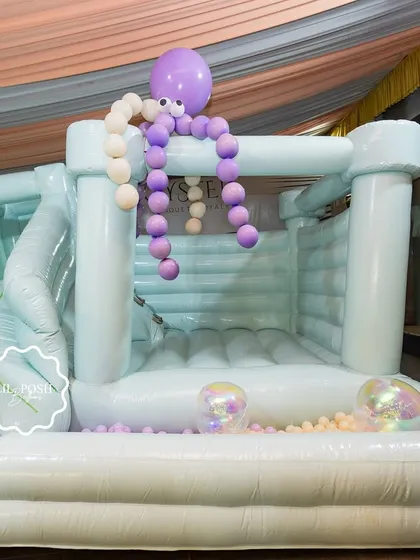 The full view of the incredible 3-in-1 bouncy castle, complete with a slide and ball pit, decorated with a balloon octopus.