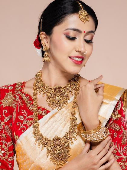 A smiling portrait of a South Indian bride, showing her jewellery and happy expression.