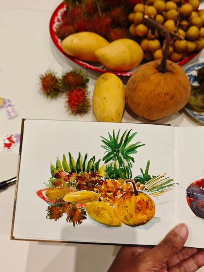 My watercolor sketchbook open to a painting of tropical fruits. I was in Thailand and was so inspired by the colorful and exotic fruits like rambutan, mangoes, and pineapple.