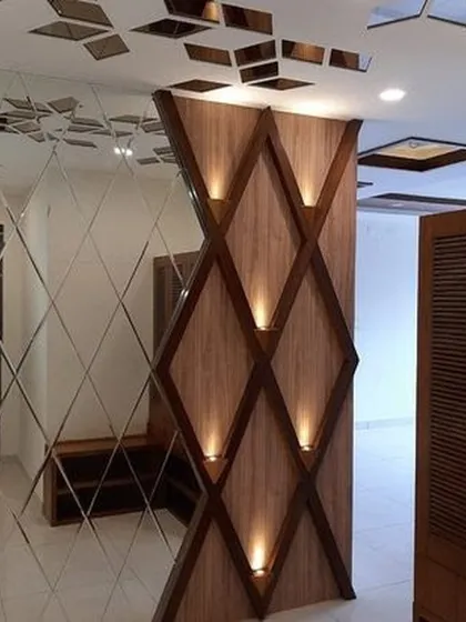 A striking accent wall with diamond-shaped wooden panels and integrated spotlights. This design, paired with a mirrored wall, creates a visually dynamic and luxurious entryway.