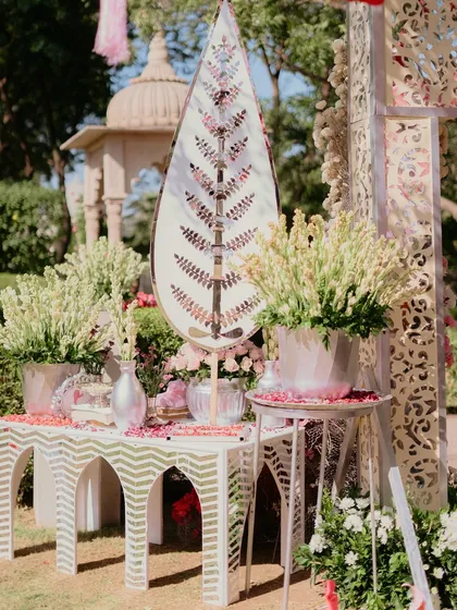 An elegant console setup at a Chooda ceremony, featuring ivory cutwork furniture, mirrored accents, and arrangements of white tuberoses, embodying grace and tradition.