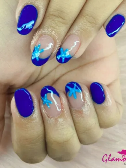 A beautiful and artistic design with a solid blue base and accent nails featuring hand-painted blue and light blue flowers.