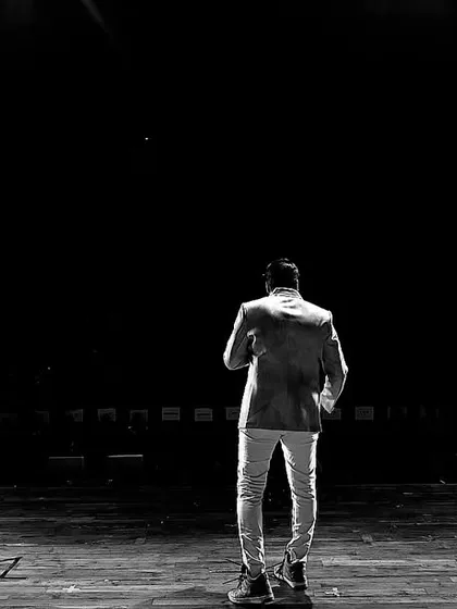 This is where I feel most at home: on stage, commanding the attention of the audience. This shot captures the feeling of holding the room, ready to bring the energy for a blockbuster annual show.