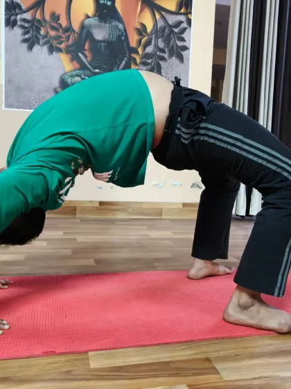 Another student works on his Wheel Pose, focusing on lifting the chest and maintaining strong arms. Each practice brings us closer to the full expression of the asana.