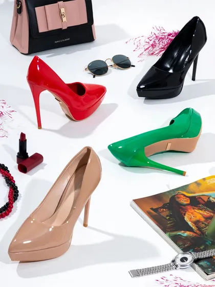 A vibrant and busy flat lay showcasing multiple styles of women's heels. This type of "product dump" shot is energetic and great for showcasing the variety in a new collection.