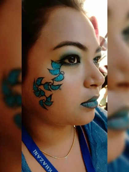 This profile view of the blue leaf fantasy makeup shows the seamless blend of the eyeshadow and the clean lines of the face art.