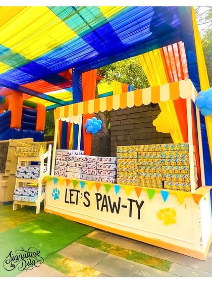 The party favour station, cleverly themed as a 'Let's Paw-ty' stall under a colourful canopy, filled with goodies for the little guests to take home.