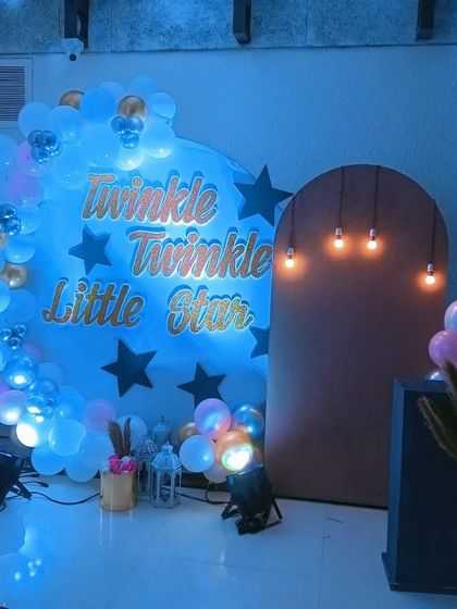 This baby shower setup uses a mix of props, including lanterns and a star-themed backdrop, to create a magical ambiance.