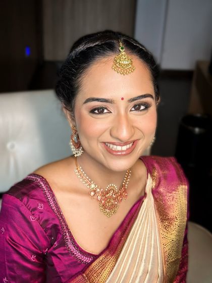 A bright, happy smile from the bride-to-be, her makeup enhancing her joyful expression.