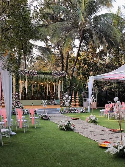 The lawn at Farmhouse Collective is a blank canvas for your event. Here, it's set up for an elegant ceremony with pink and white decor, showcasing the spacious seating arrangement under canopy tents.