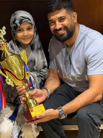 A young champion holding her first-place trophy from the Open State Taekwondo Championship. This is a huge achievement and a proud moment for our entire dojang.