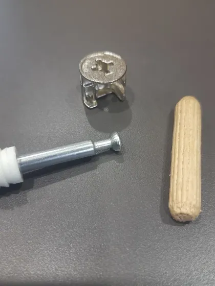 The components of modern modular furniture: a wooden dowel for alignment, a mini-fix bolt, and a cam lock for strong, hidden, and reversible connections.